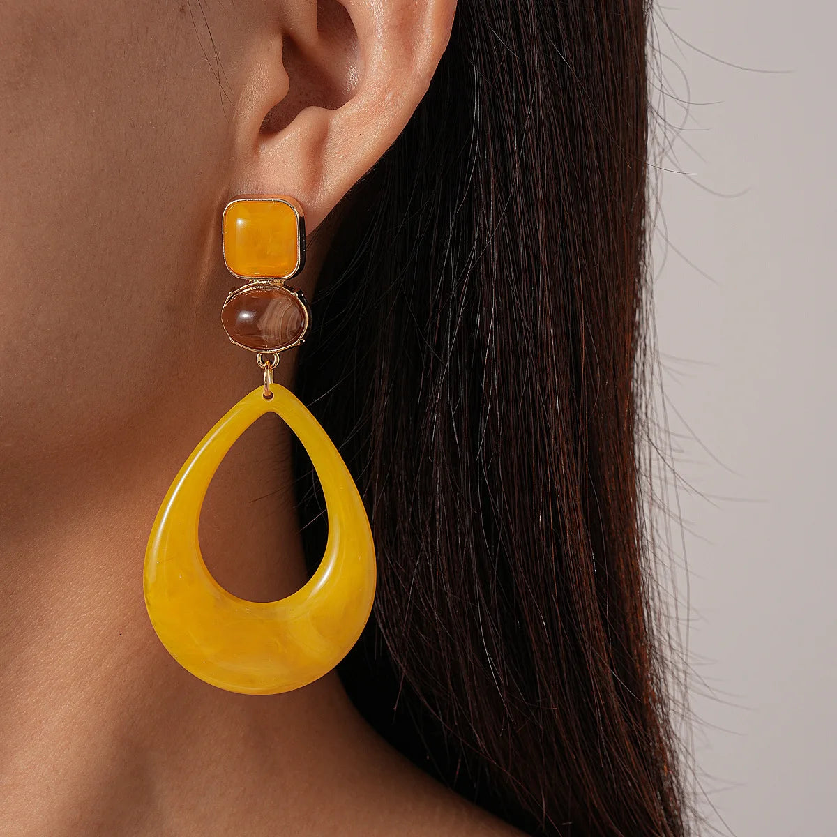 Yellow teardrop statement earring worn to show its length