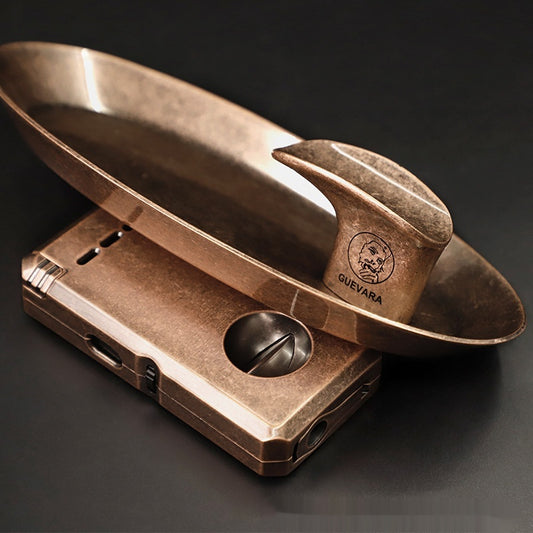 Oval ashtray beside a cigar cutter and a cigar
