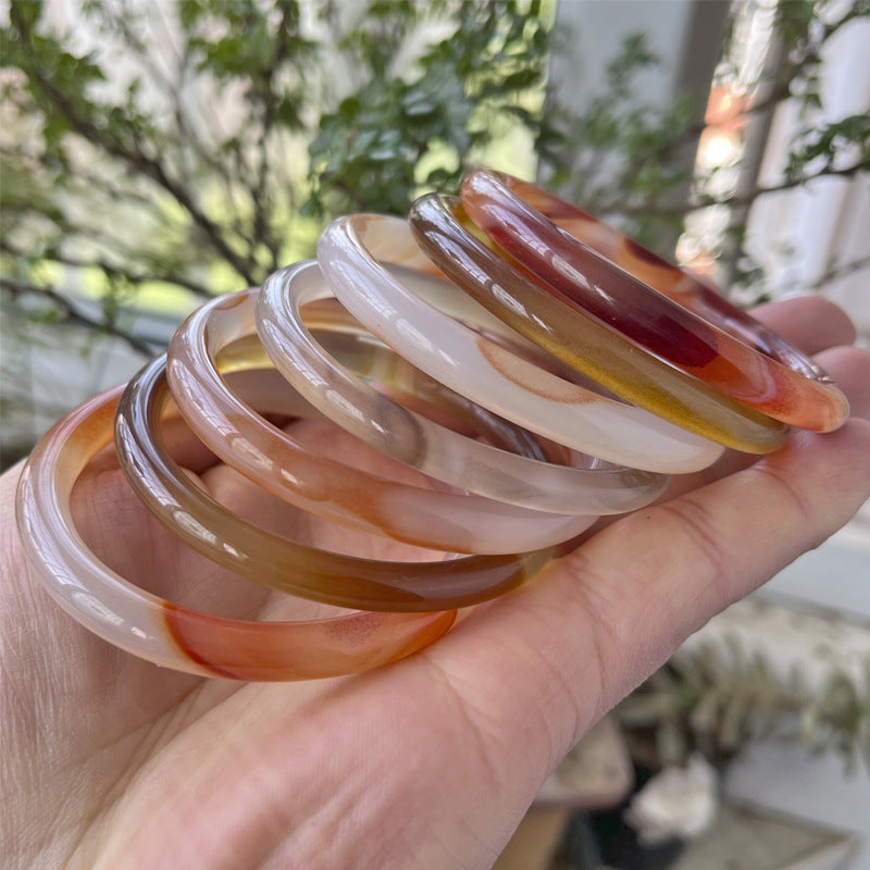 Mixed-color translucent bangles held in a hand
