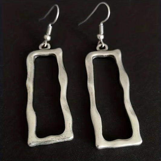 Pair of irregular open rectangle earrings on a dark background