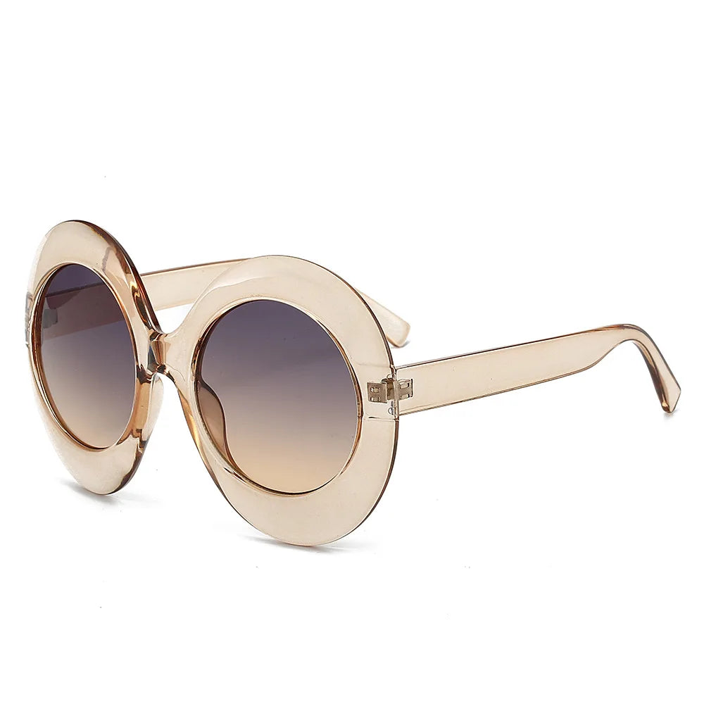Oversized round champagne-colored sunglasses with gradient lenses