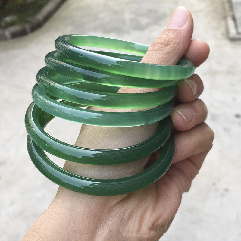 Green bangles shown in a stack against an outdoor background