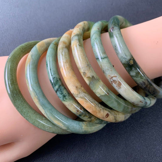 Several floral-pattern bangles worn together on a wrist
